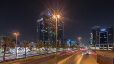Suudi Arabistan, Riyad 'ın şehir manzarası gece zaman çizelgesi. Işıklı kulelerin, gökdelenlerin, King Fahd Yolu 'nun ve yoğun trafiğin panoramik görüntüsü. Palmiyeler ve sokak lambaları şehrin içinden geçen ana otoyolda.