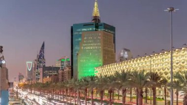 Suudi Arabistan, Riyad 'daki Kral Fahd Yolu' nun hava-gece zaman çizelgesi. Aydınlatılmış Riyad Ulusal Kütüphanesi yakınlarında modern kuleler ve gökdelenlerle çevrili araçlar ve taksilerle dolu.