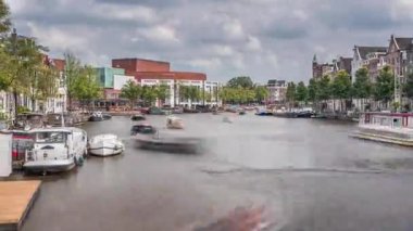 Ulusal Opera Müziği ve Tiyatro Salonu 'nun dış cephesinin aşırı hızlanması. Amsterdam 'daki nehirde, bulutlu bir gökyüzünün altında yüzen yüzen evler. Hollanda 'daki popüler turizm beldesi