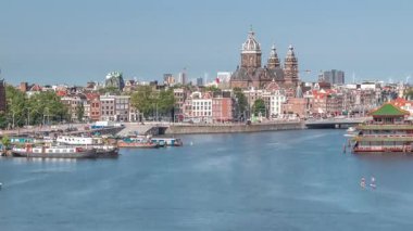 Sudaki pagoda biçiminde bir Çin restoranının hava manzarası, tarihi şehir merkezi binalarının ve nehir kıyısındaki yüzen teknelerin zeminine karşı kurulur. Amsterdam, Hollanda