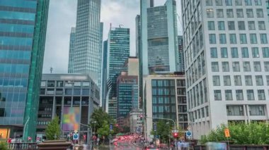 Frankfurts Innenstadt bölgesindeki cam gökdelenlere bakıyorum. Modern mimari gökyüzünde yağmurlu bulutları yansıtır. Yol ayrımında trafik vardı. Almanya.