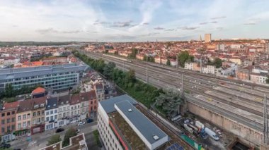 Brüksel Kuzey İstasyonu 'nun tren rayları, gelen ve giden trenlerle dolu. Schaerbeek akşam şehir manzarası kırmızı çatılar, sanayi bölgeleri ve bulutlu bir gökyüzü. Belçika