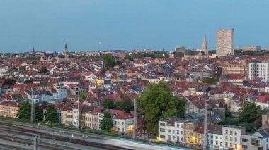 Tren istasyonu yakınlarındaki Schaerbeek 'te Brüksel ufuk çizgisi üzerinde hava gününden geceye geçiş zamanı panoraması. Konut blokları, Saint-Servais Kilisesi ve belediye binası Belçika 'nın kırmızı çatılarıyla çevrili.