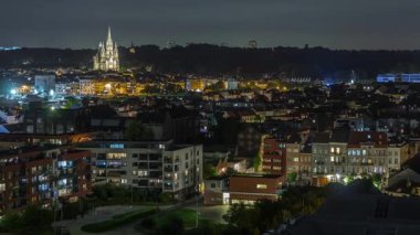 Belçika 'nın Brüksel Başkent Bölgesi, Laeken zaman ölçümünün hava panoramasında Eglise Notre-Dame de Laeken ile aydınlatılmış şehir manzarası sergilenmektedir. Tarihi cazibe ve kentsel gelişimin karışımı