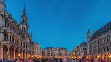 Belçika, Brüksel 'deki Grand Place Grote Markt' ın günden geceye geçiş dönemi aşırı hızlanması. Brabantine Gotik Belediye Binası, Maison Grand-Place ve tarihi şehir merkezinde gün batımından sonra turistler