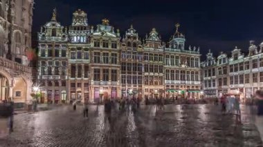 Belçika, Brüksel 'deki Büyük Yer Loncaları cephesinin gece sürati. Barok mimari zaman çizelgesinde yer alan tarihi sanat dernekleri ve UNESCO listesindeki kare üzerinde yürüyen insanlar