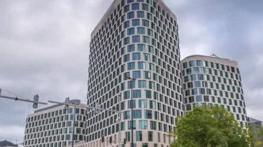 Baudouin Bulvarı, Brüksel, Belçika 'daki iş alanındaki trafik ve modern ofis binalarının zaman çizelgesi. Kavşağın yanındaki çağdaş kuleler bulutlu bir gökyüzünün altına park ederler.