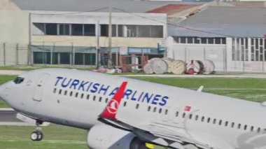 Lizbon, Portekiz - 25 Şubat 2025: Lizbon Havaalanı 'ndan kalkan uçak. Türk Hava Yolları 'nın kentin ufuk çizgisi ve havaalanı altyapısı ile pistten kalkış görüntülerini yakından izliyoruz.
