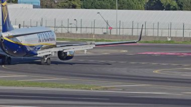 Lizbon, Portekiz - 25 Şubat 2025: Lizbon Havaalanı 'na indikten sonra terminallere giden ticari uçak. Ryanair Havayolları şehir silueti ve havaalanı altyapısı ile taksilerde ilerliyor.