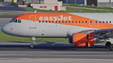 Lizbon, Portekiz - 25 Şubat 2025: Lizbon Havaalanı 'na indikten sonra terminallere giden ticari uçak. EasyJet Havayolları şehrin silueti ve havaalanı altyapısı ile taksiyollarına devam ediyor