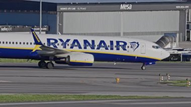 Lizbon, Portekiz - 25 Şubat 2025: Lizbon Havaalanı 'na indikten sonra terminallere giden ticari uçak. Ryanair Havayolları şehir silueti ve havaalanı altyapısı ile taksilerde ilerliyor.