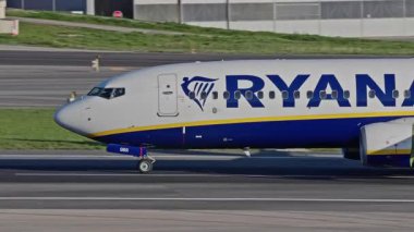 Lizbon, Portekiz - 25 Şubat 2025: Lizbon Havaalanı 'na indikten sonra terminallere giden ticari uçak. Ryanair Havayolları şehir silueti ve havaalanı altyapısı ile taksilerde ilerliyor.