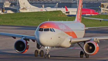 Lizbon, Portekiz - 25 Şubat 2025: Yoğun bir Lizbon havaalanının pistinde ticari uçaklar EasyJet taksileri, terminaller, diğer uçaklar ve arka planda bir şehir manzarası. Havanın canlı atmosferi