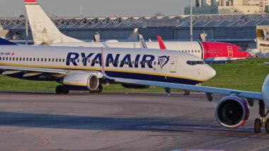 Lizbon, Portekiz - 25 Şubat 2025: Ryanair ve Wizzair ticari uçakları yoğun bir Lizbon havaalanının pistinde, terminaller, diğer uçaklar ve arka planda bir şehir manzarasıyla birlikte. Canlı.