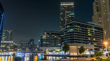 Dubai Marina, yatları ve briç gecesi hiperhızlandırılmış restoranları olan modern kuleleri olan, Birleşik Arap Emirlikleri ile dolanıyor. Gökdelenlerde parlayan pencereler