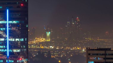 Gece vakti büyük, modern bir şehrin havadan görünüşü gece trafiği, aydınlık gökdelenler, ofis binaları. İş sahası, Dubai, Birleşik Arap Emirlikleri. Arka planda Dubai marinası