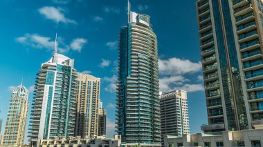 Dubai Marina Kanal Panorama 'sı yatları ve modern kuleleri ile Dubai' deki deniz kıyısından yansıtılan yeşil su, Birleşik Arap Emirlikleri. Yapay kanal ve gökdelenler