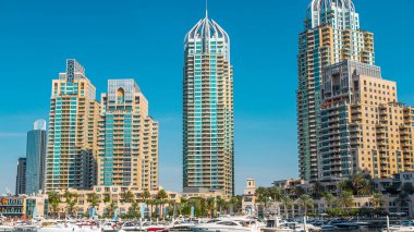 Dubai Marina Kanalı 'nın yatları ve modern kuleleri Dubai' nin deniz kıyısından yeşil suya yansıdı. Limanda tekneler