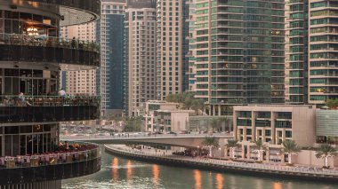 Dubai Marina rıhtımı kuleleri ve Dubai 'deki alışveriş merkezinin balkonundan restoranlara yakın köprüsü olan Birleşik Arap Emirlikleri hava geçiş zamanı..