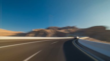 Jebel Hafeet yolundan gün batımından önce Al Ain, Birleşik Arap Emirlikleri 'ne doğru sürün. Hareket bulanık görünüm