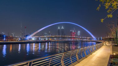 Dubai Su Kanalı gecesinde Dubai Deresi 'ni Jumeirah Sahili' ne bağlayan Dubai, Downtown Dubai ve Safa Parkı 'ndan geçen yaya köprüsü. Gökdelenlerin silueti. Birleşik Arap Emirlikleri