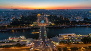 Paris, Fransa 'daki Eyfel Kulesi' nden Palais de Chaillot ile Trocadero 'ya gündüz ve gece geçiş zamanı üzerinde hava manzarası. Seine nehri ve gemisinin geçtiği gözlem güvertesinin üst görüntüsü.