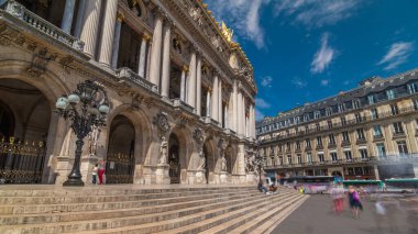 Palais veya Opera Garnier Ulusal Müzik Akademisi Paris, Fransa 'da zaman aşımına uğradı. Girişe giden merdivenler. İnsanlar sokakta yürürken ve trafikte yürürken.