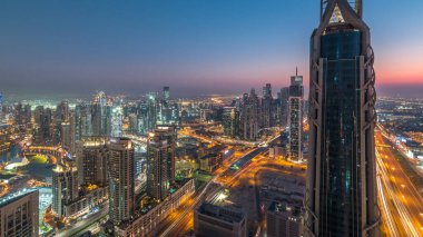 Gün gece geçiş timelapse modern için Dubai Downtown Dubai, Suudi Arabistan, üstten panoramik görünüm kuleleri. Business bay yakınındaki Şeyh Zayed Yolu üzerinde trafik