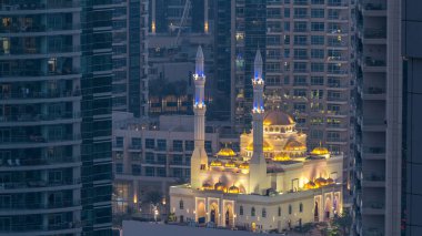 Al Raheem Camii gökdelenler gün gece geçiş timelapse Marina arasında yürümek içinde Dubai Marina, Dubai, Uae. Akşam güneş battıktan sonra hava üstten görünüm