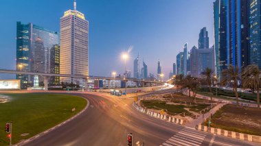 Kavşak ve köprü gece geçiş timelapse gökdelenler gün çevrili Sheikh Zayed Road üzerinde trafik. Yukarıdan akşam itibariyle Birleşik Arap Emirlikleri Dubai oteli göster