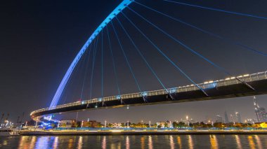 Fütüristik Dubai su kanal ışıklı gece timelapse hyperlapse, Birleşik Arap Emirlikleri, üzerinde yaya köprüsü. Cityscape arka plan üzerinde. Promenade görüntülemek