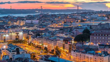 Lizbon 'da gün batımından sonra şehir merkezinin sonbahar gününden geceye geçiş zamanlarında kırmızı çatıları olan panoramik manzarası, Portekiz. Miradouro da Nossa Senhora do Monte bakış açısından üstten görünüm