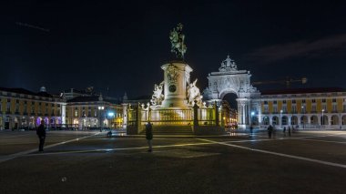 Triumphal arch at Rua Augusta and illuminated bronze statue of King Jose I at Commerce square lited at night timelapse hyperlapse in Lisbon, Portugal.