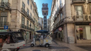 Santa Justa Elevator timelapse hyperlapse in Lisbon, Portugal. Blue sky on background. Connecting downtown to Bairro Alto. Historic buildings an a walking streets