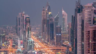 Dubai şehir merkezinde gökdelenler ve Gece geçiş timelapse, Dubai, Birleşik Arap Emirlikleri Şeyh Zayed yol gün havadan görünümü. Modern kuleler ve karayolu üzerinde akşam trafiği