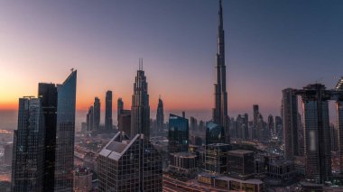 Dubai şehir merkezi silueti en yüksek gökdelenler ve karayolu kavşak gece gündüz geçiş timelapse üzerinde en işlek trafik ile. Yukarıdan havadan görünüm