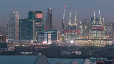 Dubai şehir merkezi mimarisi ile Aerial cityscape ve günlük geçiş timelapse, Birleşik Arap Emirlikleri finans merkezi gece. Şantiye ile en yüksek kuleler ve gökdelenler