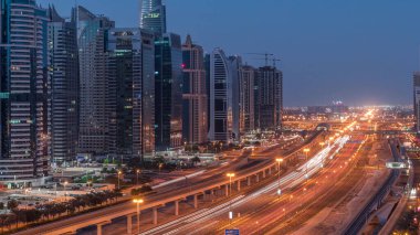 Dubai Marina 'dan Şeyh Zayed yoluna gece gündüz aydınlık gökdelenlerle geçiş zamanı, Dubai. Trafik, köprüler ve metro istasyonu. Birleşik Arap Emirlikleri