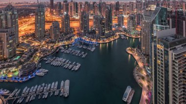 Dubai Marina, gökdelenleri ve Jumeirah göl kulelerini aydınlatmış ve Birleşik Arap Emirlikleri 'nde gece gündüz geçiş zamanlarına kadar panoramik manzara sağlamıştır. Yolda trafik ve yüzen tekneler.