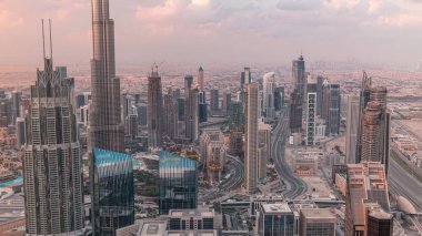 Dubai Downtown silueti fütüristik şehir manzarası ile birçok gökdelenler ve Burj Khalifa hava timelapse. Modern kuleler ve çatıdan inşaat ile gün doğumu sırasında Sabah panorama
