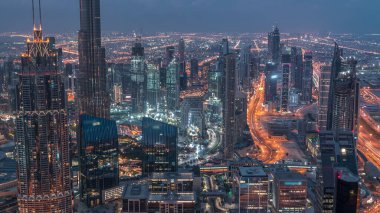 Dubai Şehir Merkezi gökdelenleri ve Burj Halife 'nin gece gündüz geçiş yaptığı fütüristik şehir manzarası. Gündoğumundan önce çatıdan modern kuleleri ve inşaatı olan sabah manzarası