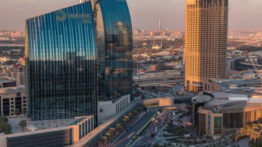 Gün batımında Dubai şehir merkezi caddesinde yoğun trafik ve gökdelenler var. Modern yol ve alışveriş merkezi manzaralı şehir binaları. Şeyh Muhammed bin Rashid Bulvarı