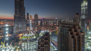 Gün doğmadan Dubai şehir merkezindeki panoramik gökyüzü manzarası alışveriş merkezleri, çeşmeler ve Burç Halife hava durumu geçiş zamanı. Modern gökdelenler ve inşaat alanı