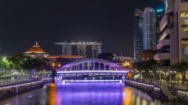 Singapur finans bölgesinin Skyline 'ı ve Elgin Köprüsü' nün arkasındaki Marina körfezi ve Singapur Nehri gece hipervanesi. Parlamento binası sol tarafta.