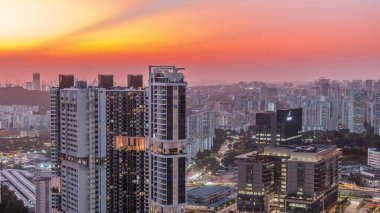 Apartman binaları ve Singapur zaman çizelgeleri olan gökdelenler. Sokakta trafik vardı. Gün batımında Skybridge bakış açısından bak