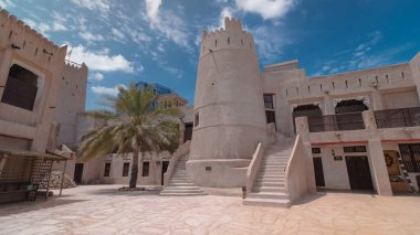 Ajman Müzesi 'ndeki tarihi kalede mavi gökyüzü, Birleşik Arap Emirlikleri ile hızlandırılmış zaman atlaması. Kuleye yakın merdivenler.