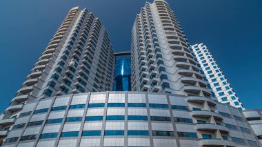 Ajman zaman ayarlı hiperhızlandırılmış gümüş kuleleri olan modern yeni mavi. Ajman 'ın yerleşim yeri ve ofis gökdelenleri olan şehir manzarası. Birleşik Arap Emirlikleri.