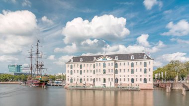 Denizcilik Müzesi 'nin hiperlapse' si ve Amsterdam 'ın deniz kenarı kopyası. Bulutlu mavi gökyüzü. Kültürel aktiviteleri, kanalları ve köprüleri meşhurdur. Amsterdam, Hollanda