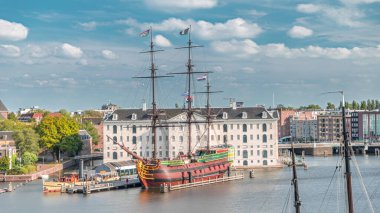 Denizcilik Müzesi 'nin zamanlaması ve Amsterdam' ın teknesinin kopyası yakında. Bulutlu mavi gökyüzü. Kültürel aktiviteleri, kanalları ve köprüleri meşhurdur. Amsterdam, Hollanda