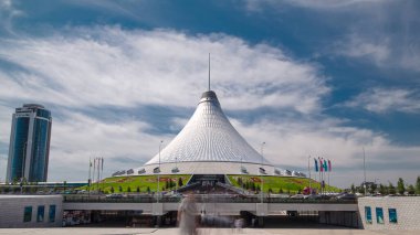 Kazakistan, Nur-Sultan 'da Khan Shatyr zaman atlaması. Khan Shatyr Kazakistan Cumhuriyeti 'nin başkenti Astana' da yer almaktadır. Şehir sakinleri yürüyor ve dinleniyor..